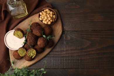 Photo of Delicious falafel balls served on wooden table, top view. Space for text