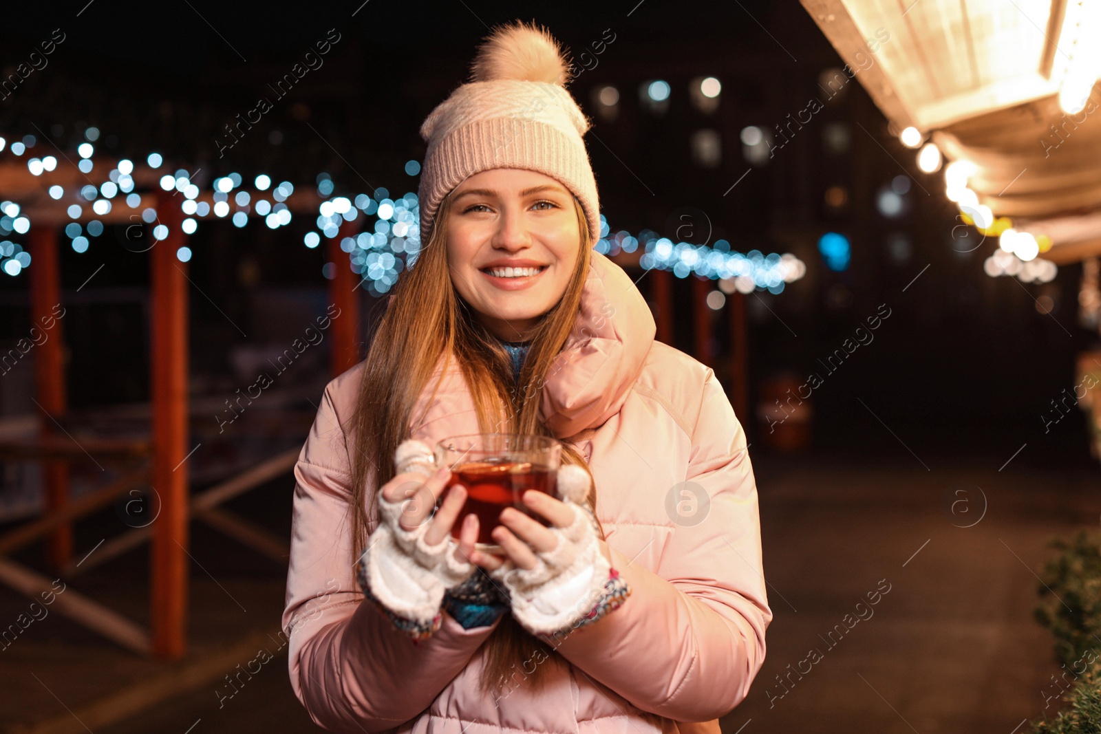 Photo of Happy woman with mulled wine at winter fair