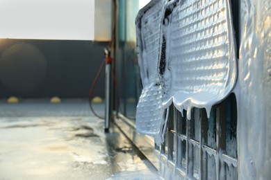 Photo of Auto mats covered with foam hanging at car wash