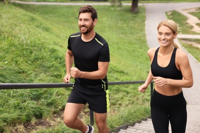 Photo of Healthy lifestyle. Happy couple running up stairs outdoors