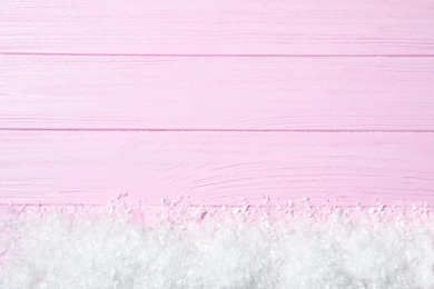 Heap of snow and space for text on pink wooden background, top view. Christmas time