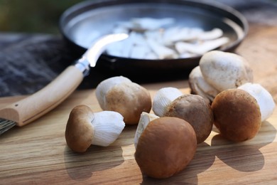 Photo of Fresh mushrooms on wooden table outdoors, closeup