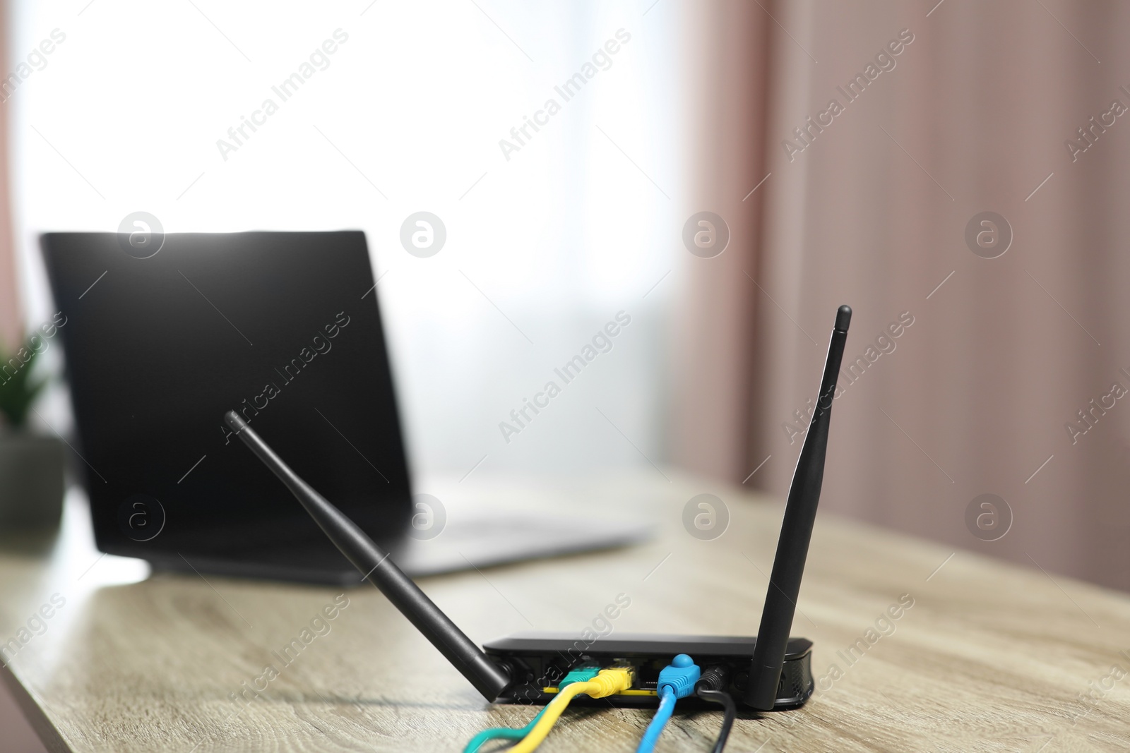 Photo of New modern Wi-Fi router on wooden table indoors
