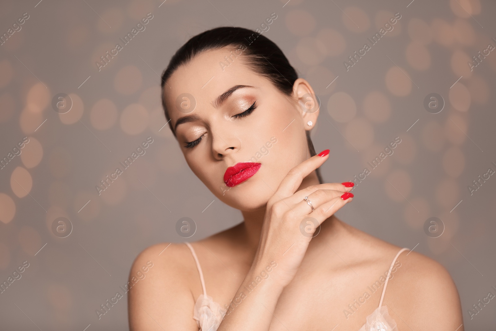 Photo of Portrait of beautiful young woman with bright manicure on blurred background. Nail polish trends