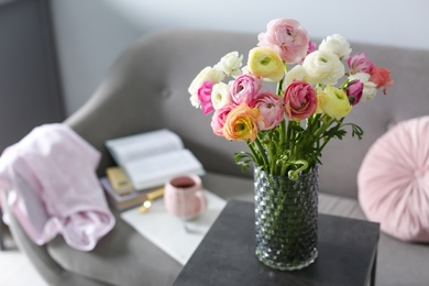 Photo of Bouquet of beautiful ranunculuses on table in living room. Space for text
