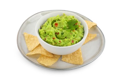 Delicious guacamole served with nachos chips isolated on white