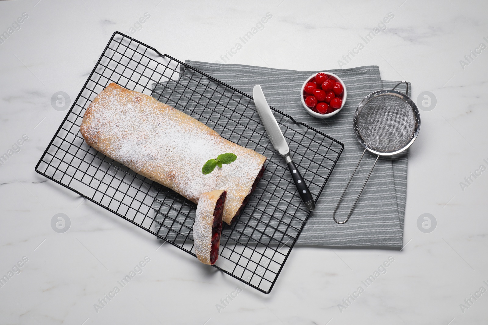 Photo of Delicious strudel with tasty filling served on white marble table, flat lay