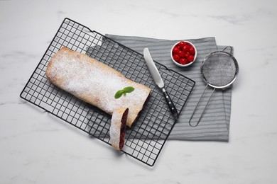 Delicious strudel with tasty filling served on white marble table, flat lay