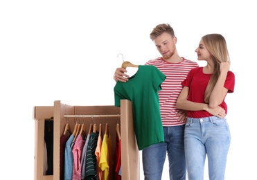 Young couple near wardrobe boxes on white background