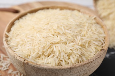 Raw rice in bowl on table, closeup