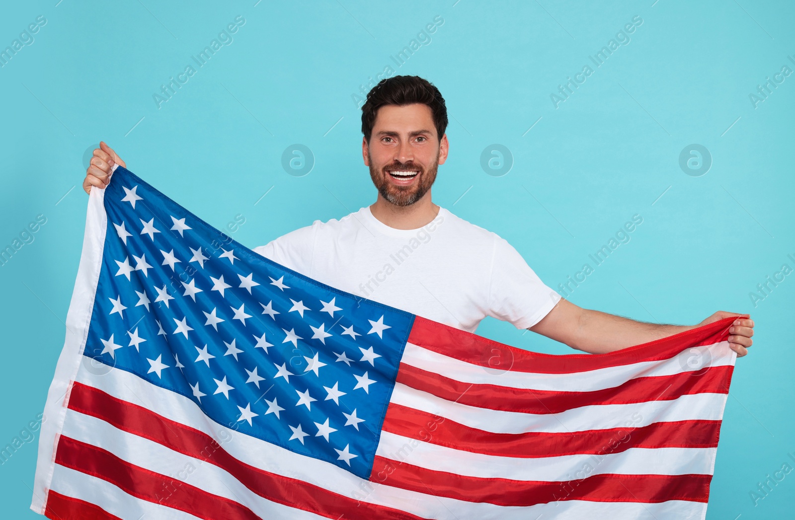 Photo of 4th of July - Independence Day of USA. Happy man with American flag on light blue background