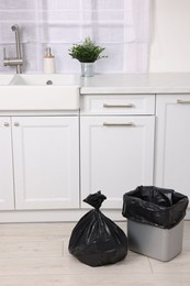 Photo of Plastic garbage bag and trash can in kitchen