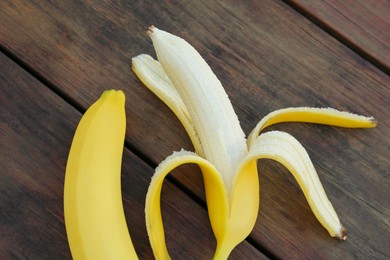 Delicious yellow bananas on wooden table, flat lay