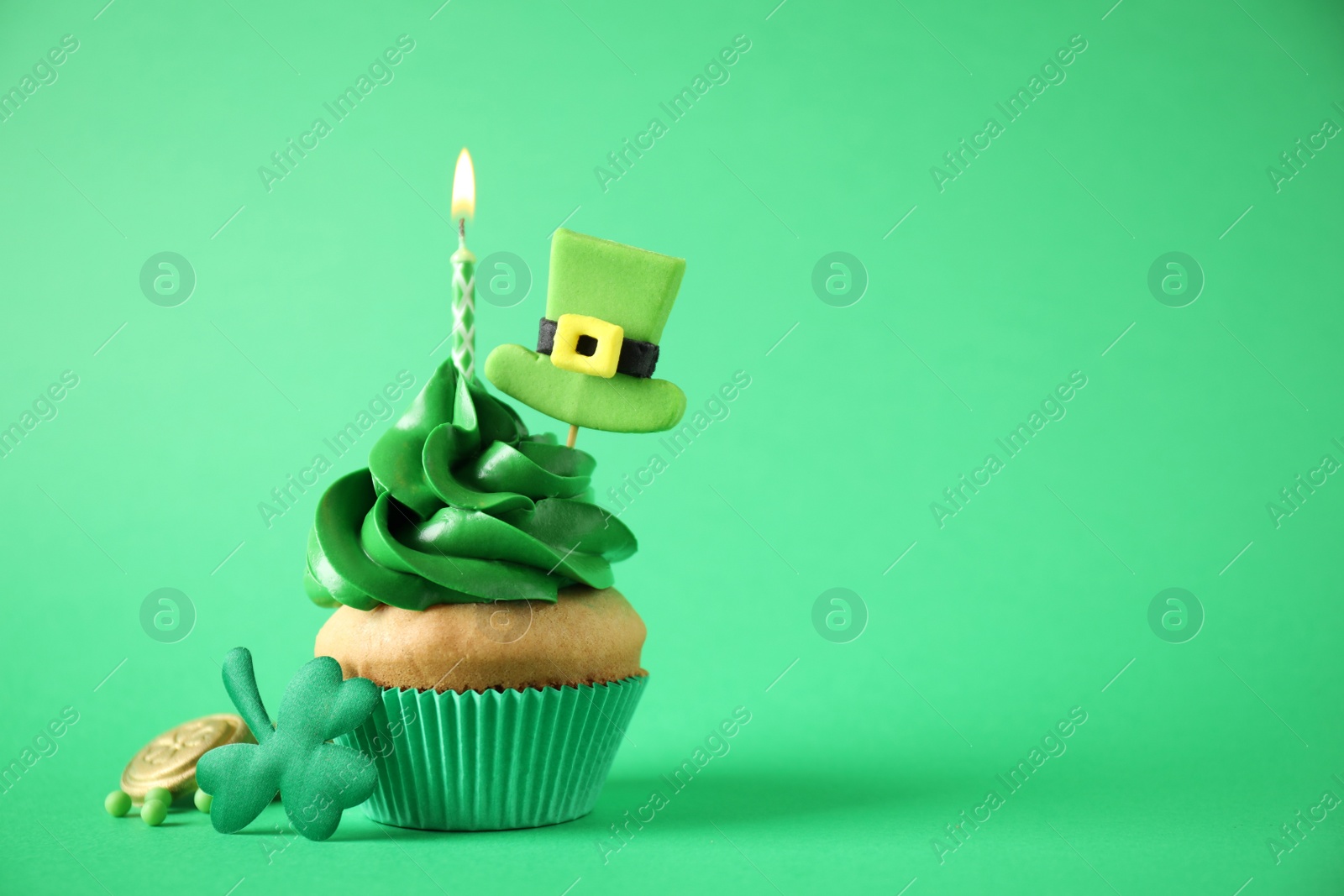 Photo of Decorated cupcake on green background, space for text. St. Patrick's Day celebration