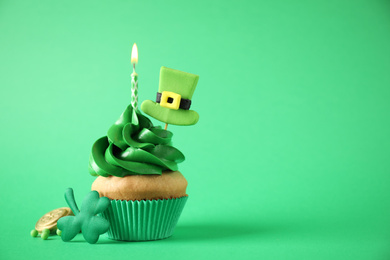 Photo of Decorated cupcake on green background, space for text. St. Patrick's Day celebration