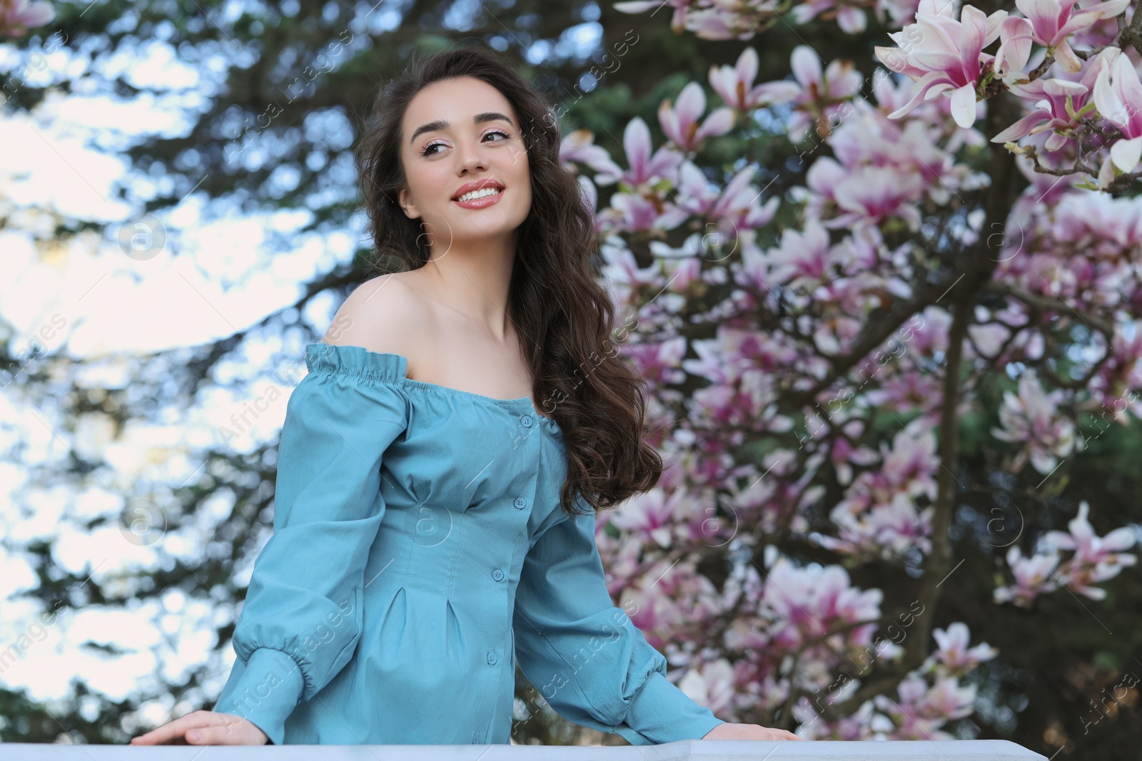 Photo of Beautiful woman near blossoming magnolia tree on spring day