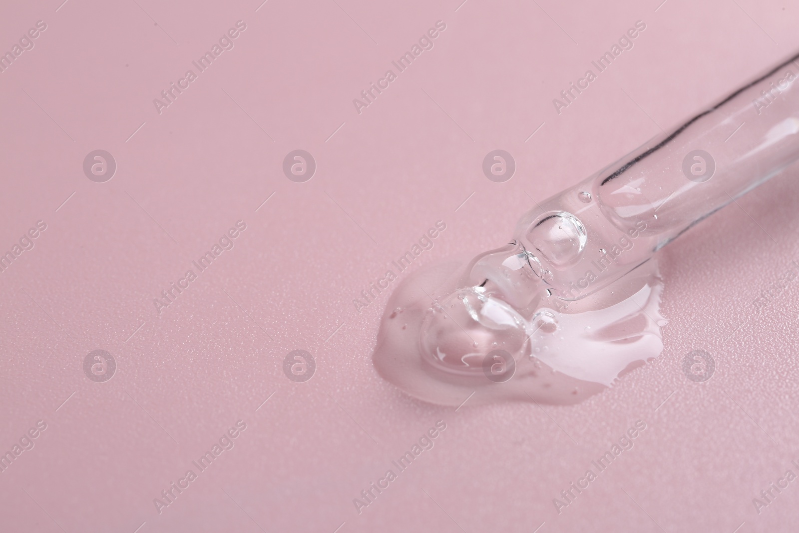 Photo of Pipette with cosmetic serum on pink background, space for text