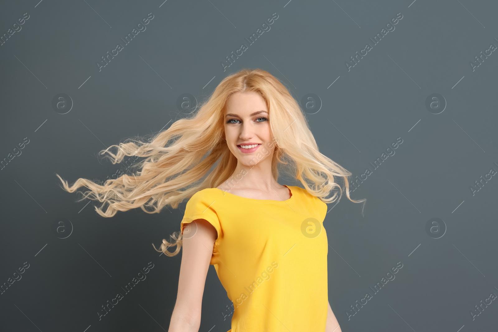 Photo of Portrait of young model with beautiful  hair on grey background