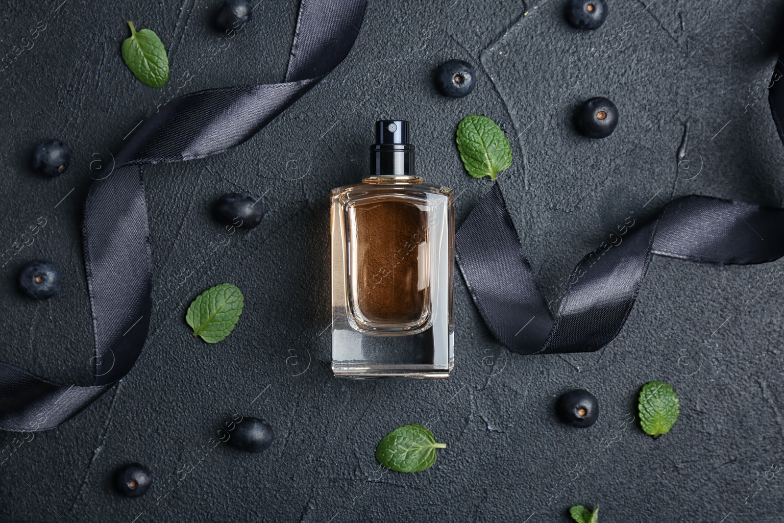 Photo of Beautiful composition with bottle of perfume on dark background, flat lay