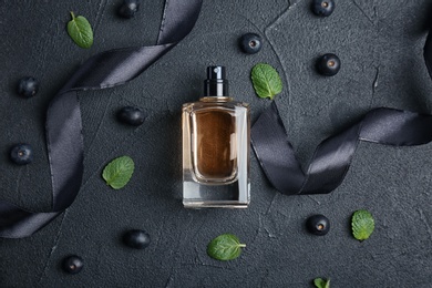 Beautiful composition with bottle of perfume on dark background, flat lay
