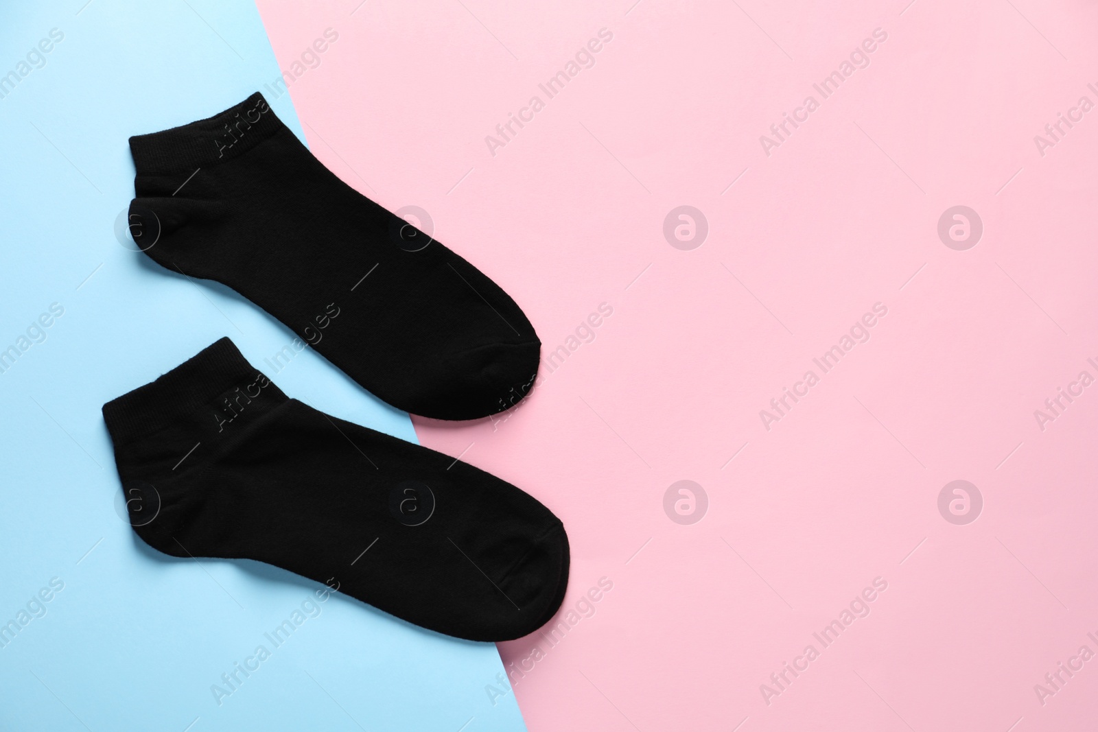 Photo of Pair of black socks on colorful background, flat lay. Space for text