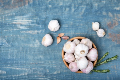 Photo of Plate with fresh garlic bulbs on wooden background, top view