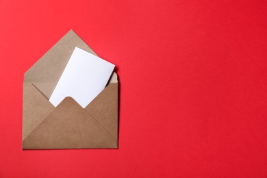 Photo of Letter envelope with card on red background, top view. Space for text