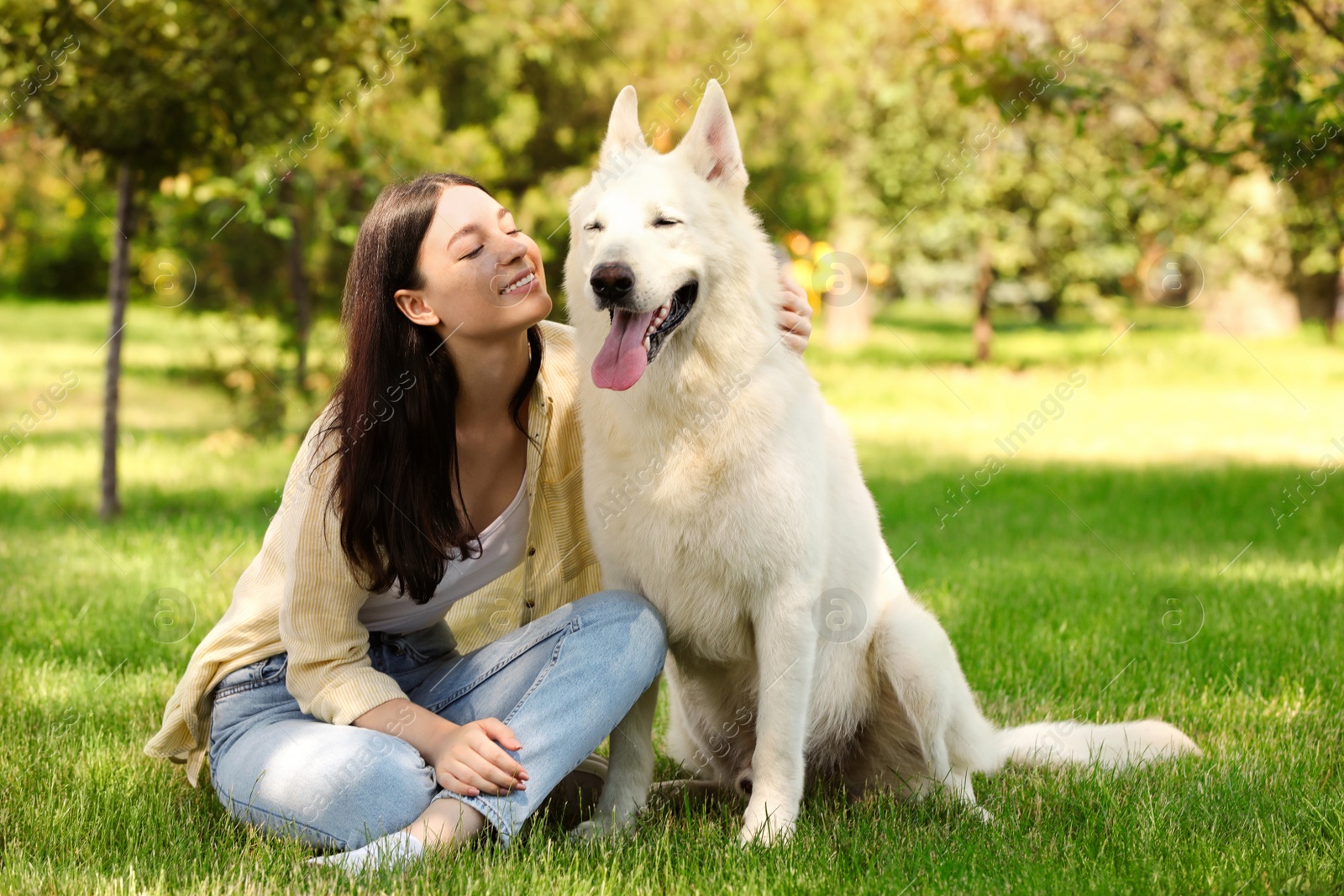 Photo of Teenage girl with her white Swiss Shepherd dog in park