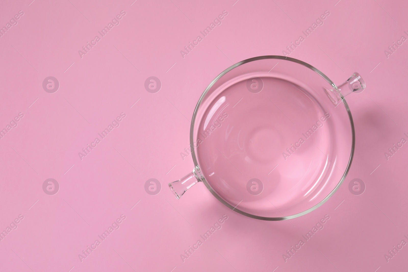 Photo of Empty glass pot on pink background, top view. Space for text