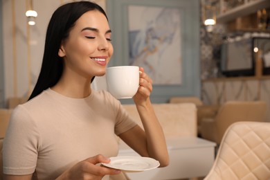 Photo of Woman enjoying delicious coffee at cafe in morning