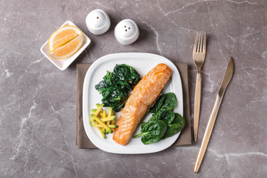 Photo of Tasty salmon with spinach and avocado served on marble table, flat lay