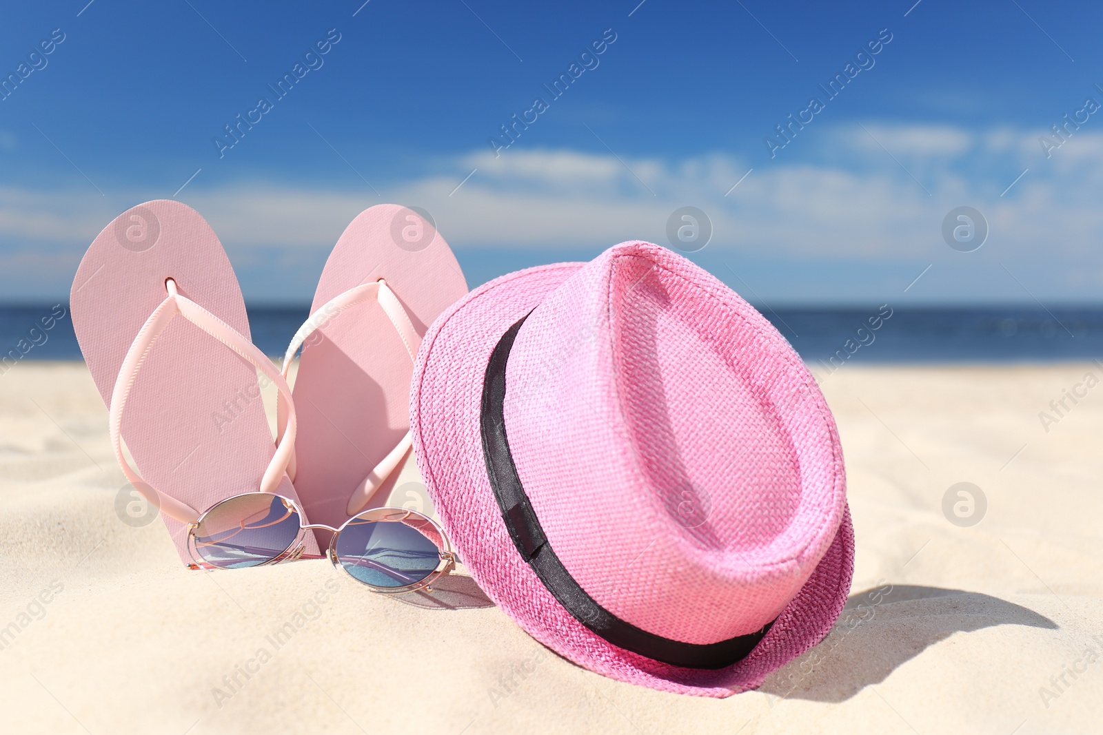 Photo of Stylish beach accessories for summer vacation on sand near sea