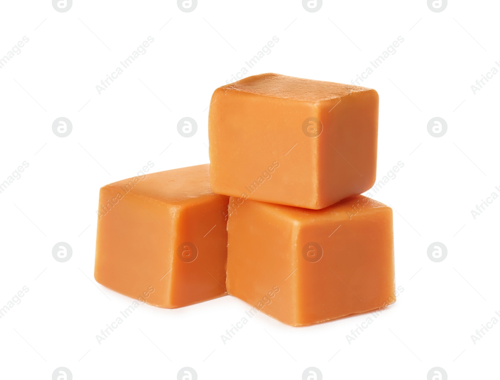 Photo of Three caramel cubes on white background. Confectionery