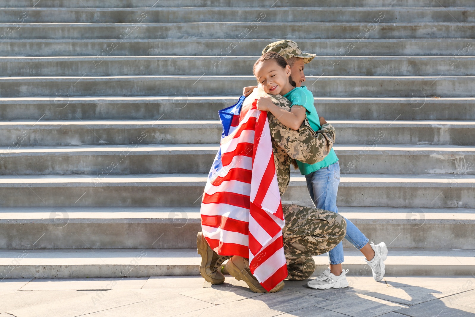 Photo of Soldier with flag of USA and his little daughter hugging outdoors, space for text