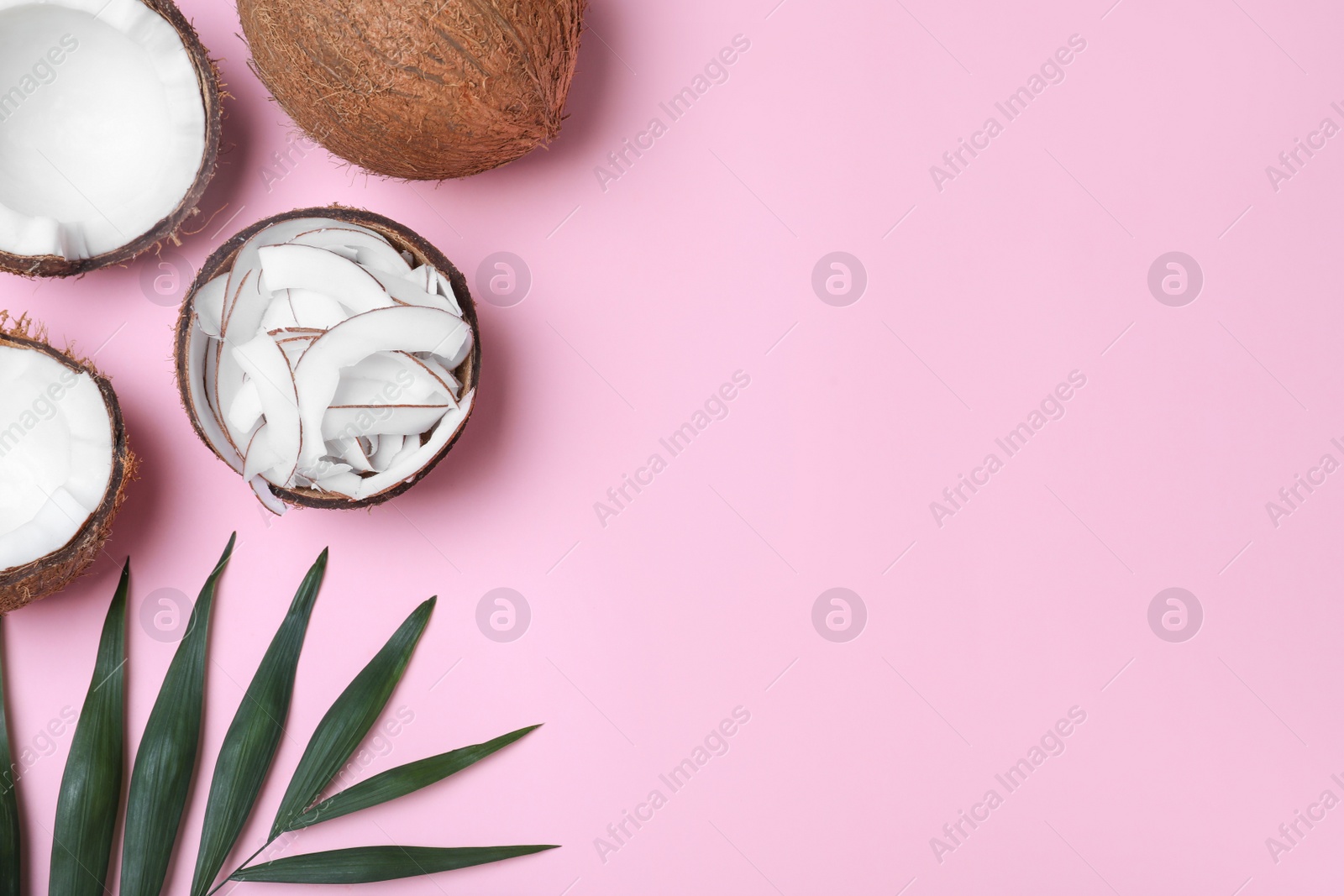 Photo of Flat lay composition with fresh coconut flakes on pink background. Space for text