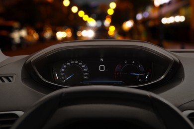 Image of Dashboard with speedometer behind steering wheel inside car