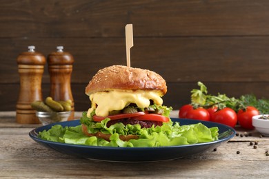 Photo of Delicious vegetarian burger and ingredients on wooden table