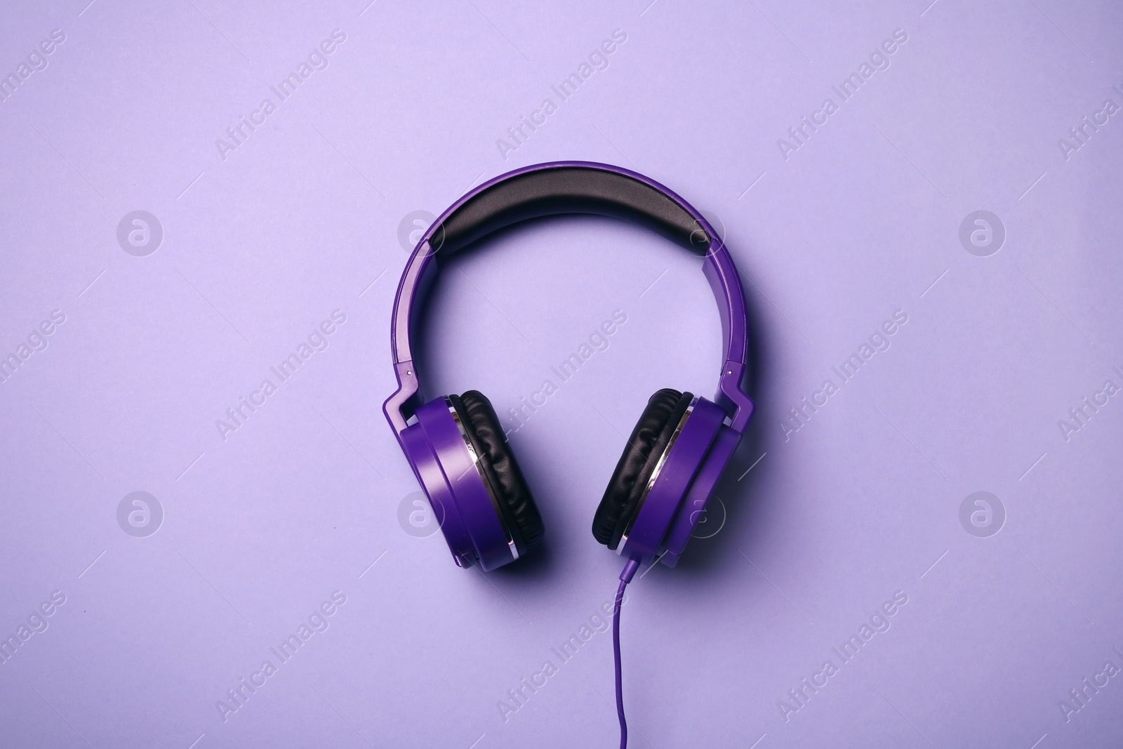 Photo of Stylish modern headphones on color background, top view