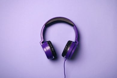 Stylish modern headphones on color background, top view