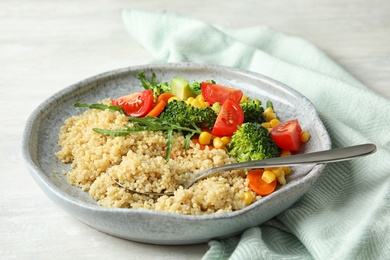 Photo of Plate with quinoa and different vegetables on table