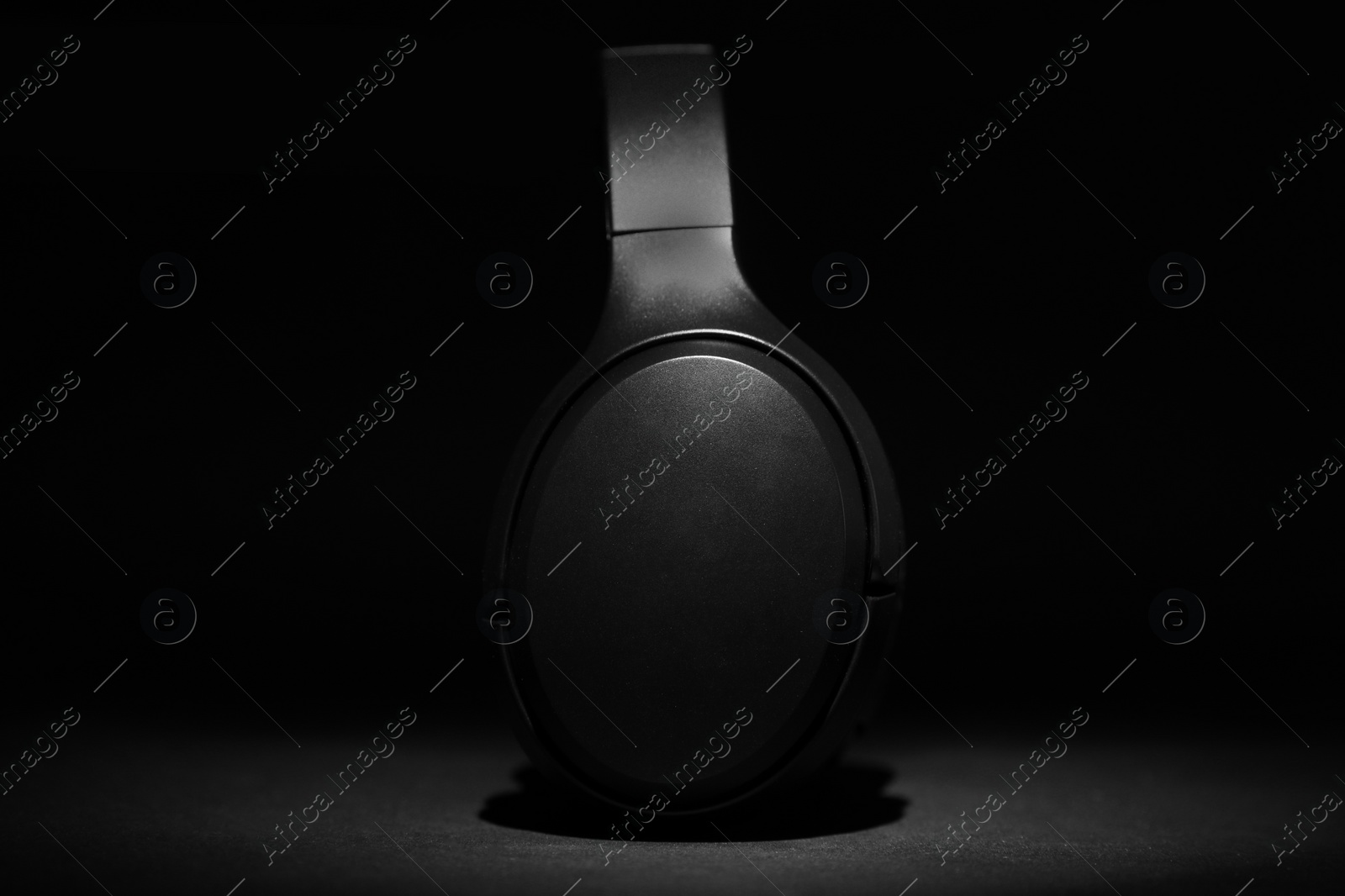 Photo of Stylish modern wireless headphones on black background