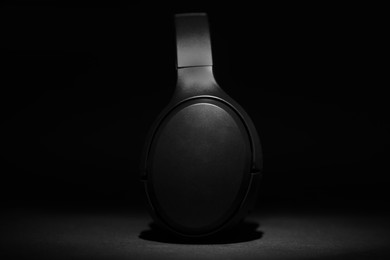 Photo of Stylish modern wireless headphones on black background