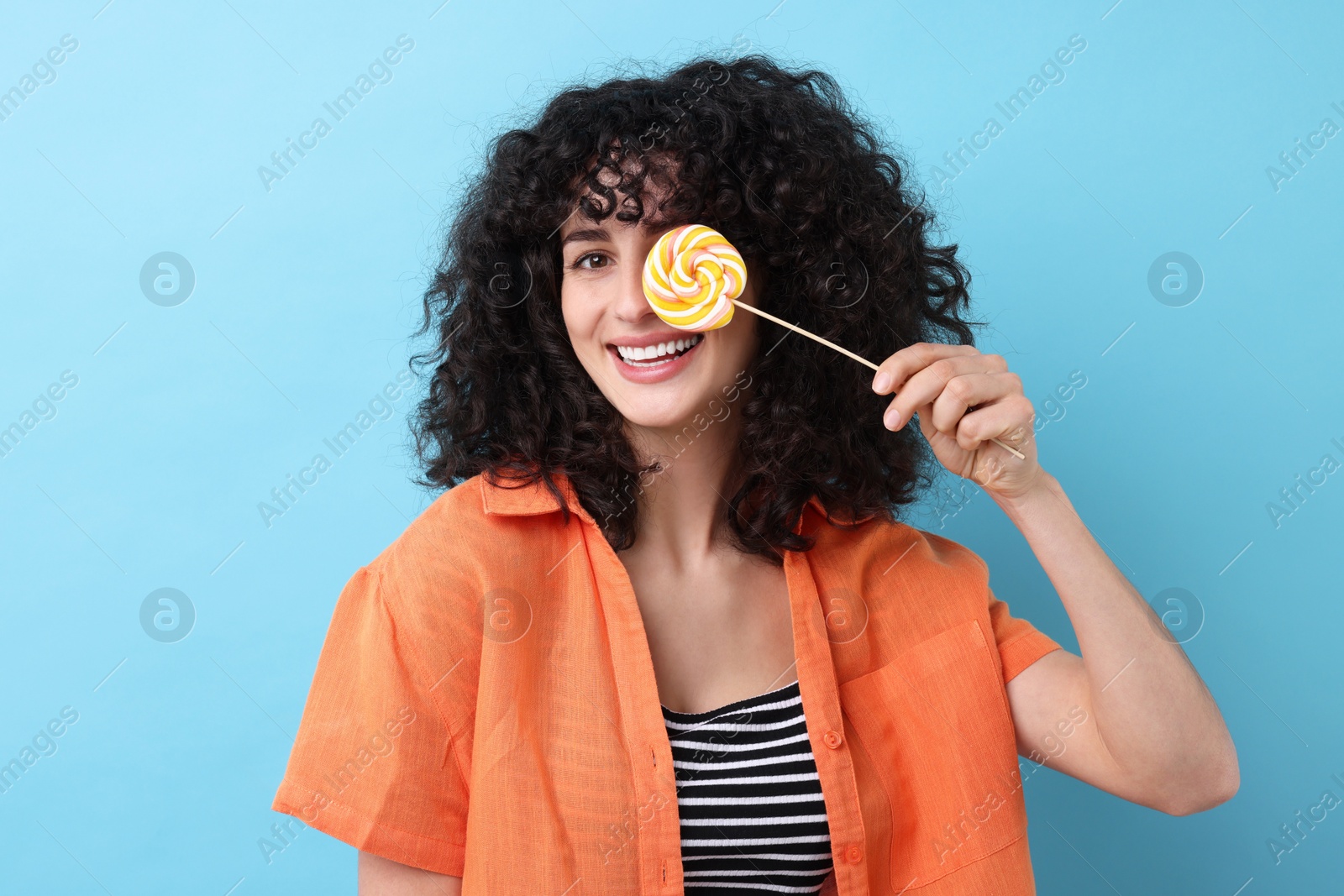 Photo of Beautiful woman with lollipop on light blue background