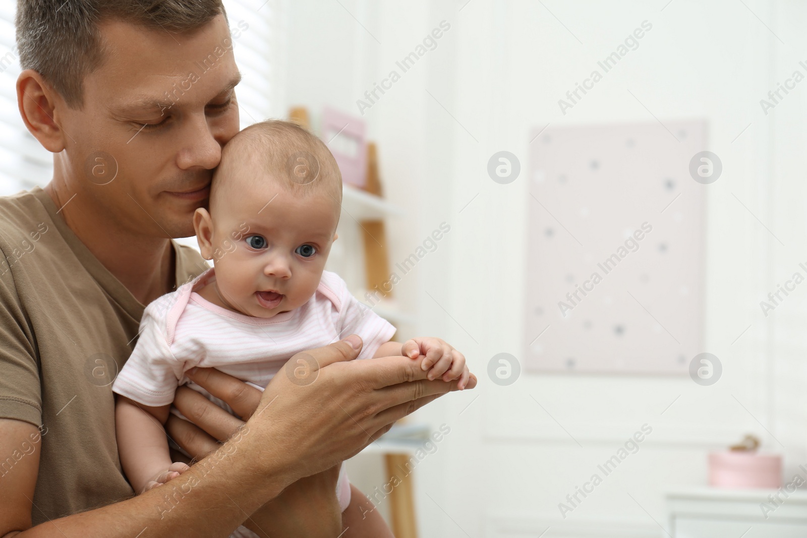 Photo of Happy father with his little baby at home. Space for text