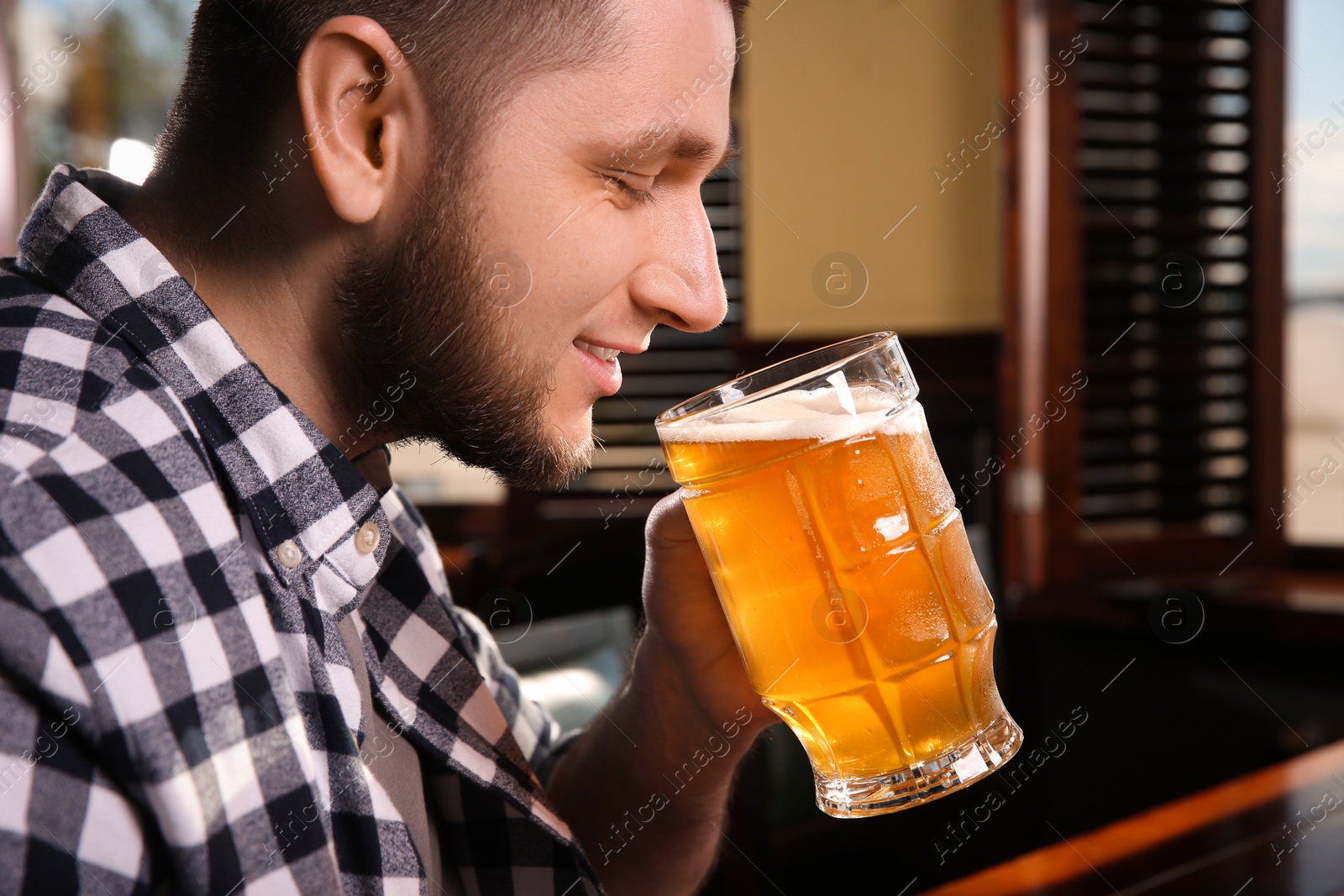 Photo of Man drinking tasty beer in pub, closeup