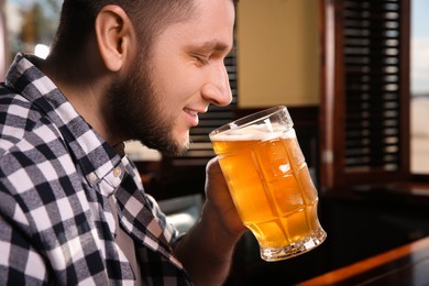 Man drinking tasty beer in pub, closeup