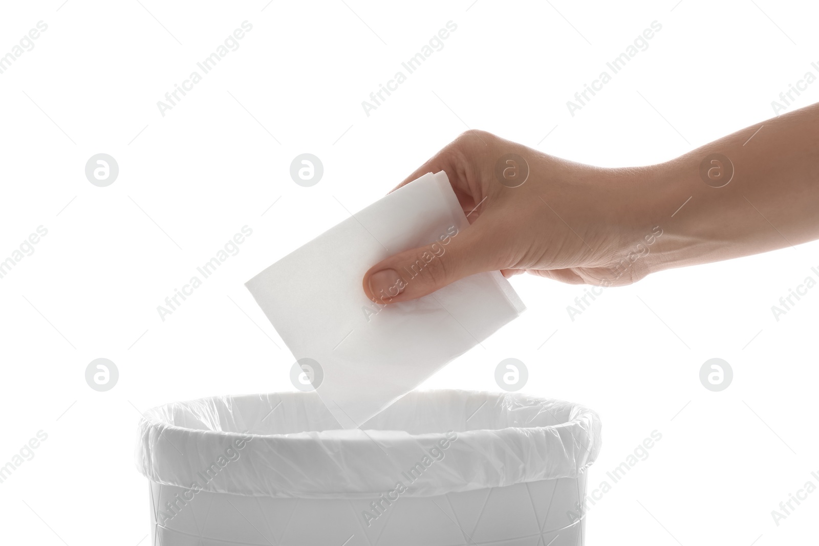 Photo of Woman putting paper tissue into trash bin on white background, closeup