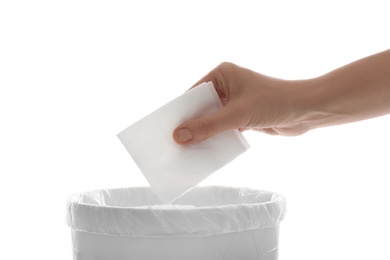 Photo of Woman putting paper tissue into trash bin on white background, closeup