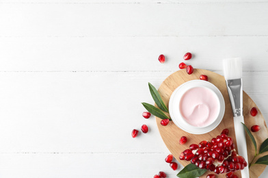 Photo of Flat lay composition with natural pomegranate facial mask on white wooden table. Space for text