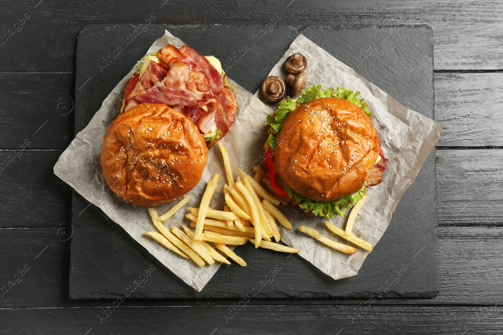 Photo of Burgers with bacon and french fries on table, top view